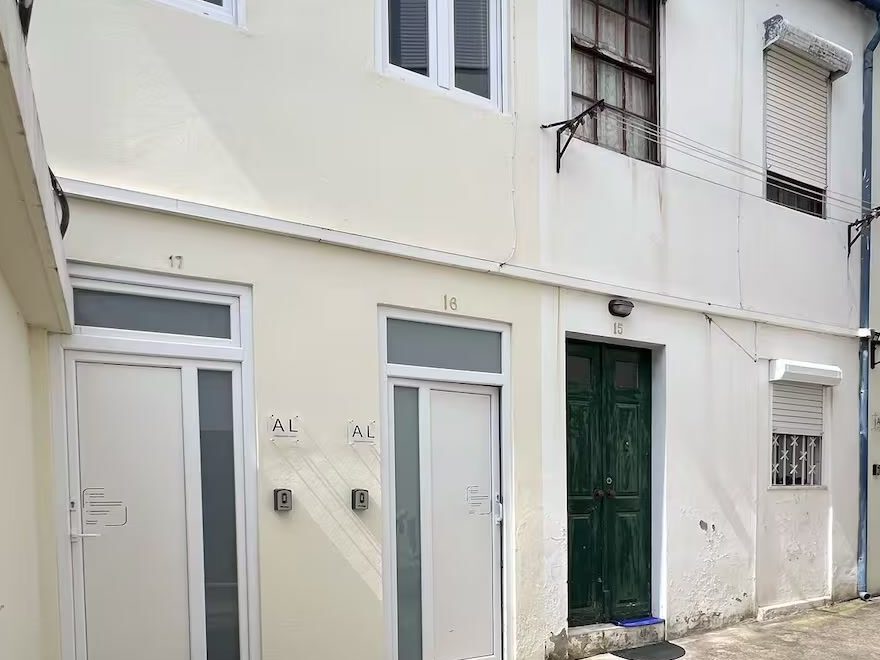 The two front doors inside the ilha, numbered 17 and 16, each with a small Alojamento Local plaque beside it